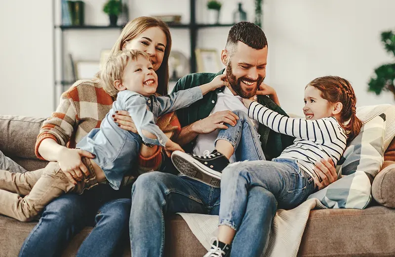 family laughing and playing in living room